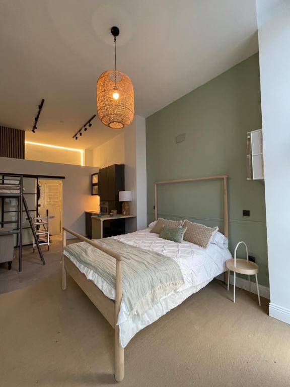 a bedroom with a large bed and a pendant light at Origen Valladolid in Valladolid