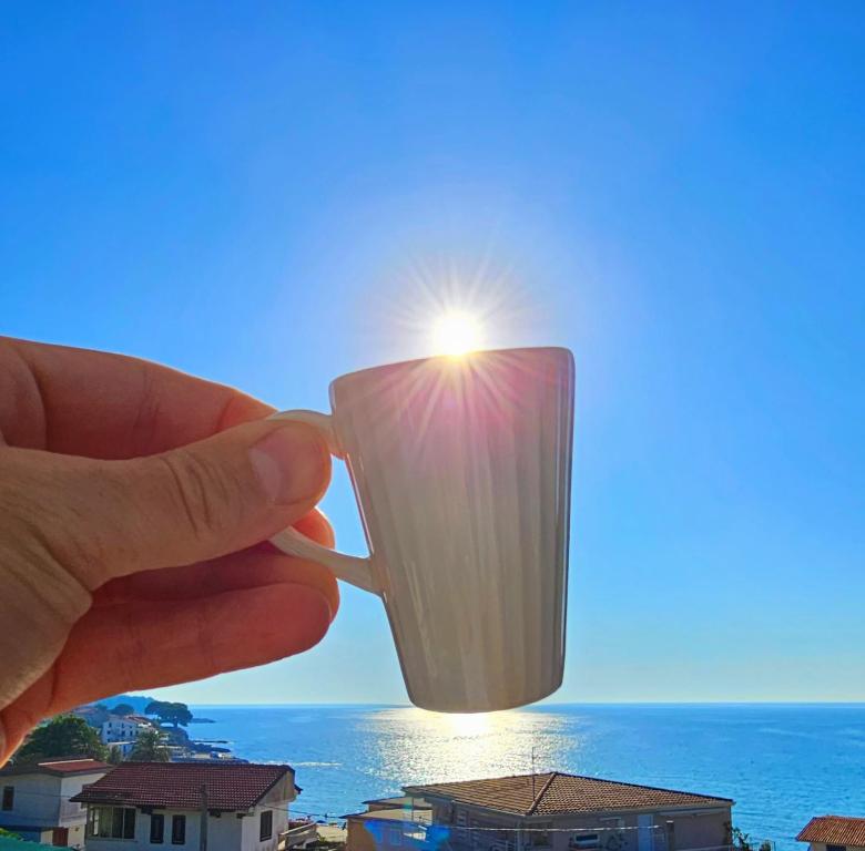 a person holding a candle in front of the sun at A Casa di Alessandra - Rooms in Castellabate