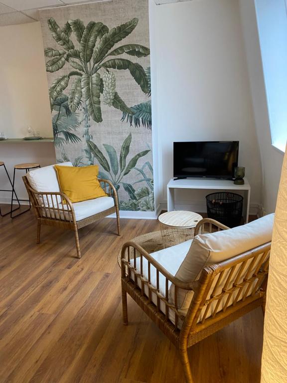 a living room with two chairs and a tv at Studio Malo les bains plage in Dunkerque