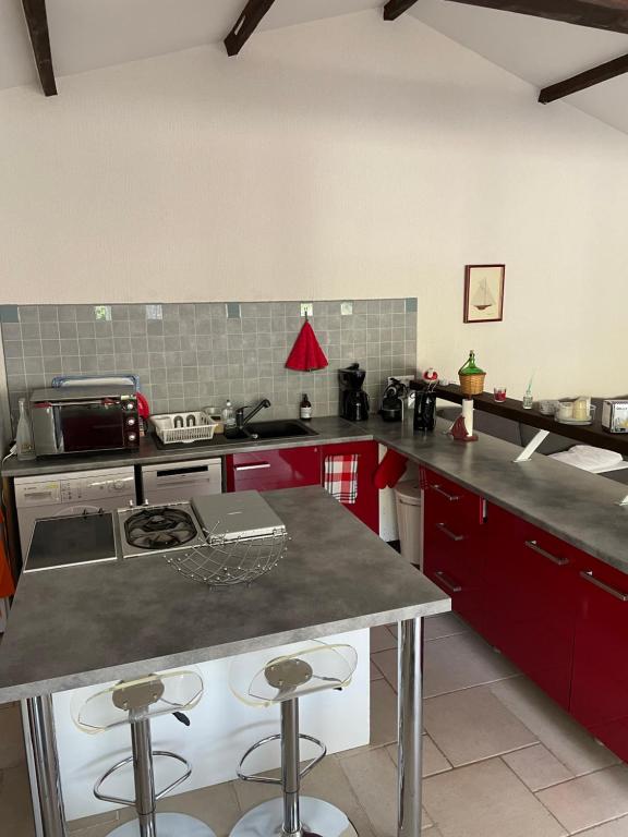 a kitchen with red cabinets and a counter top at Joli pavillon individuel in Carry-le-Rouet