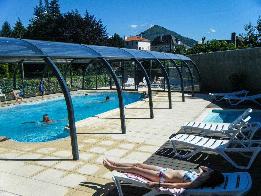 a woman laying in chairs in a swimming pool at CAMPING PLEIN SOLEIL in Lourdes