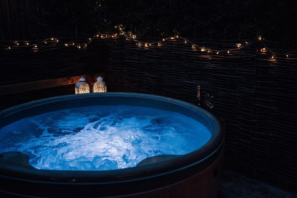 a blue tub with two bottles of water and lights at Luxury Farm Cottage with Hot Tub in Northallerton