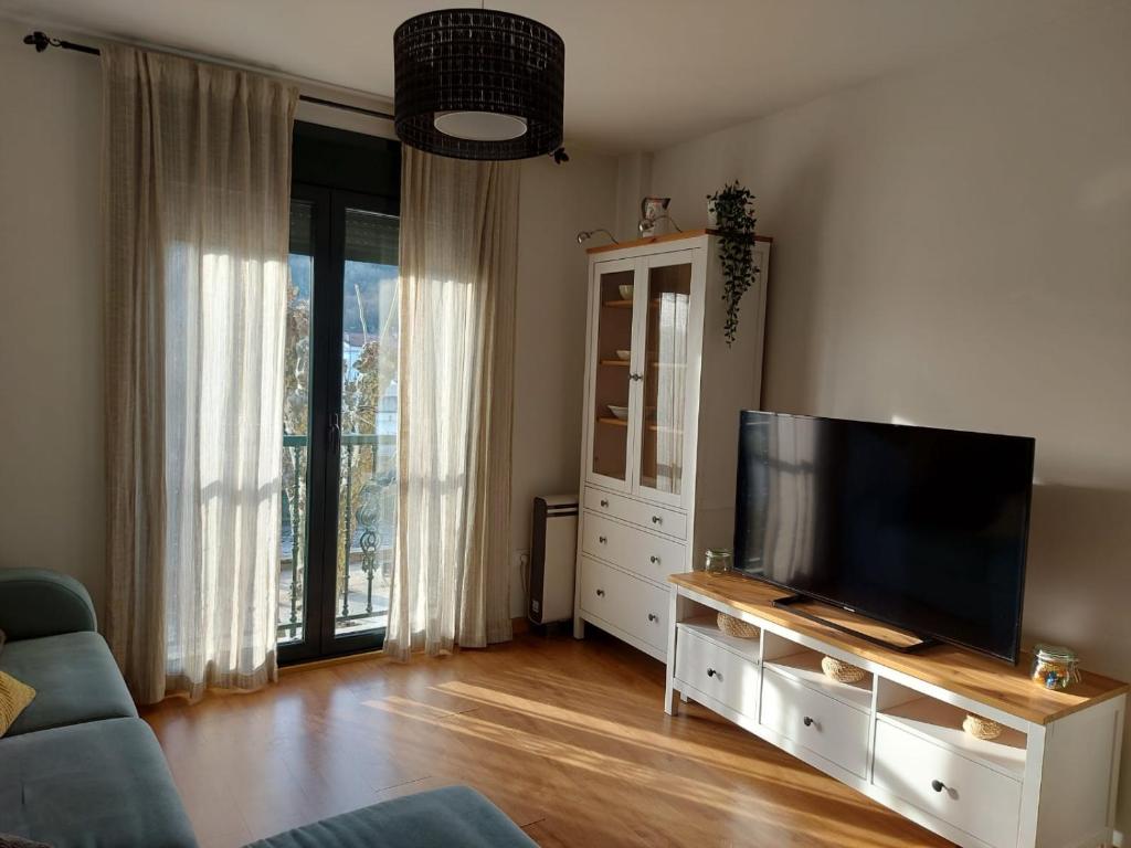een woonkamer met een grote flatscreen-tv bij Piso do Espolón in Padrón