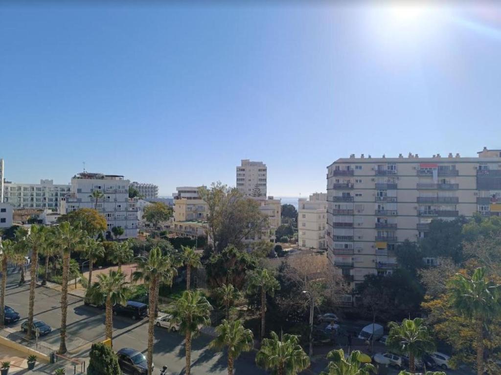 uno skyline della città con palme e edifici di Nelvir Studio Benalmádena a Benalmádena