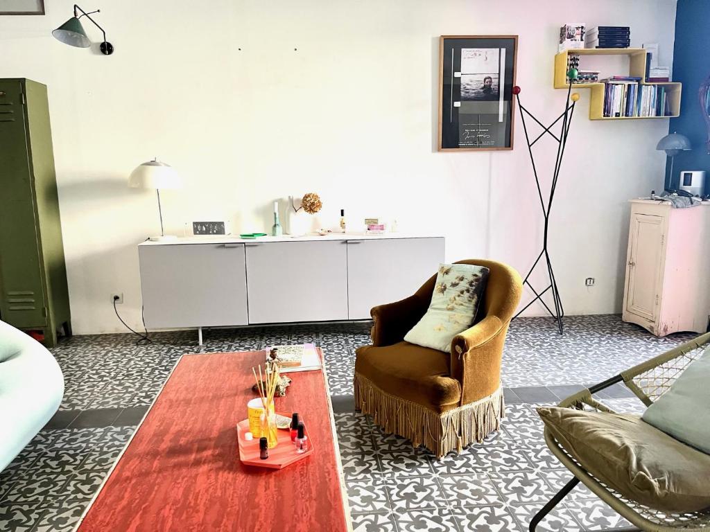 - un salon avec une chaise et une table basse dans l'établissement Maison au Vallon des Auffes Marseille, à Marseille