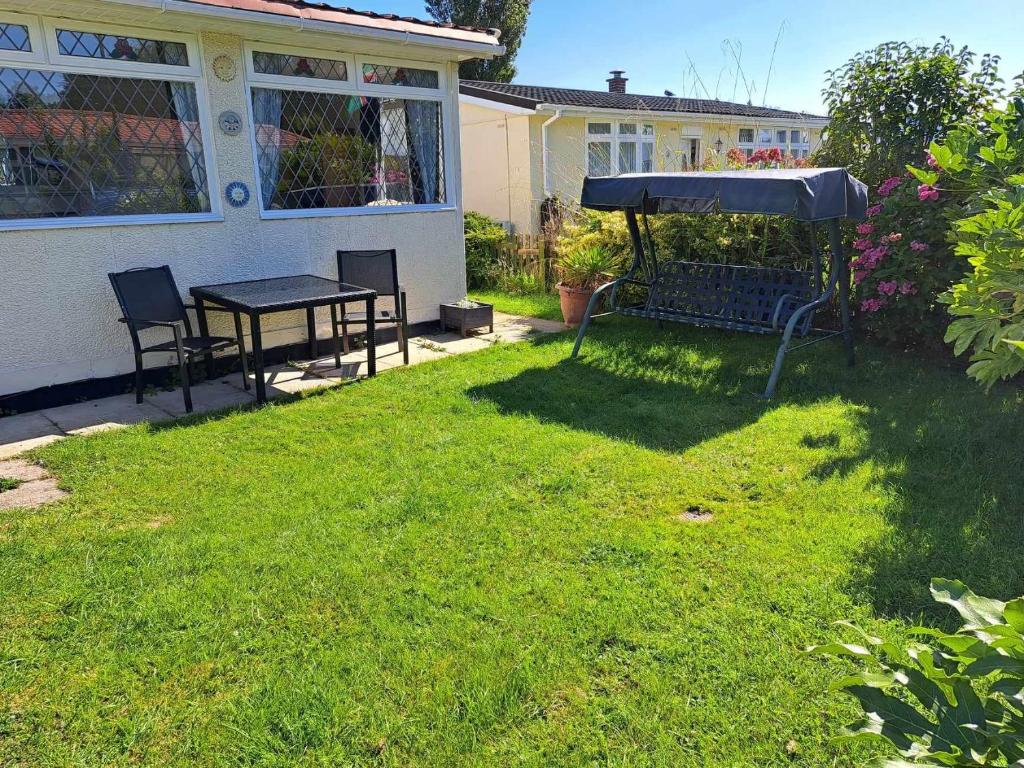 a backyard with a table and an umbrella at Beach & Tonic beachside chalet in Humberston