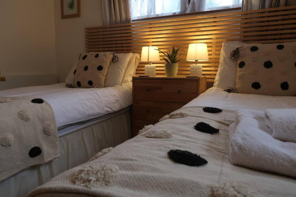 two beds sitting next to each other in a bedroom at Cosy 2-bedroom cottage in the Lake District in Bowness-on-Windermere