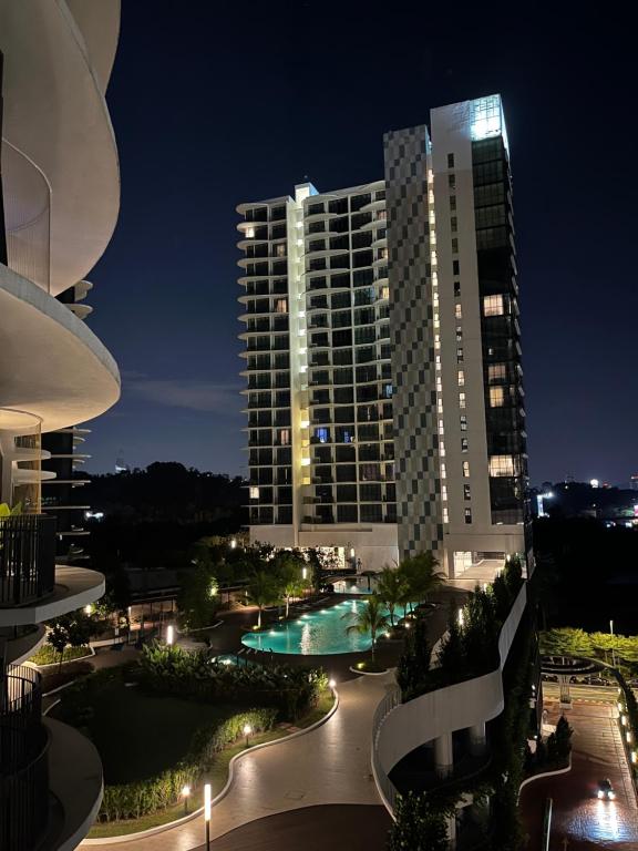 a large building with a pool in front of it at Homestay KLGCC KL Golf Country Club Senada Residences in Kuala Lumpur