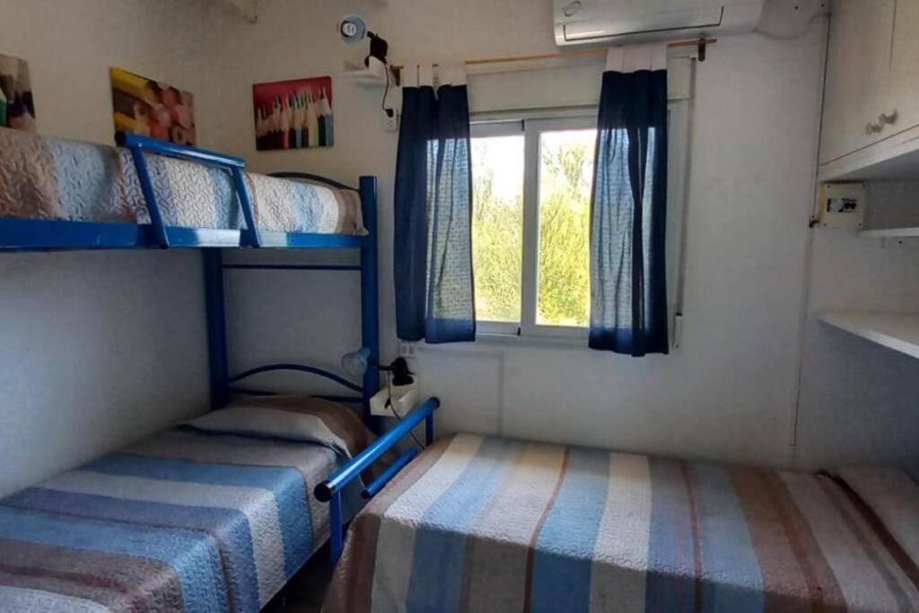 Un dormitorio con dos literas y una ventana. en Cómodo dúplex frente al mar, en Monte Hermoso