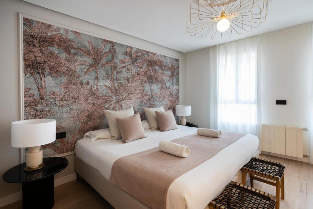 sypialnia z dużym łóżkiem i dużym obrazem na ścianie w obiekcie YOU & CO. J. Botánico Boutique w Walencji