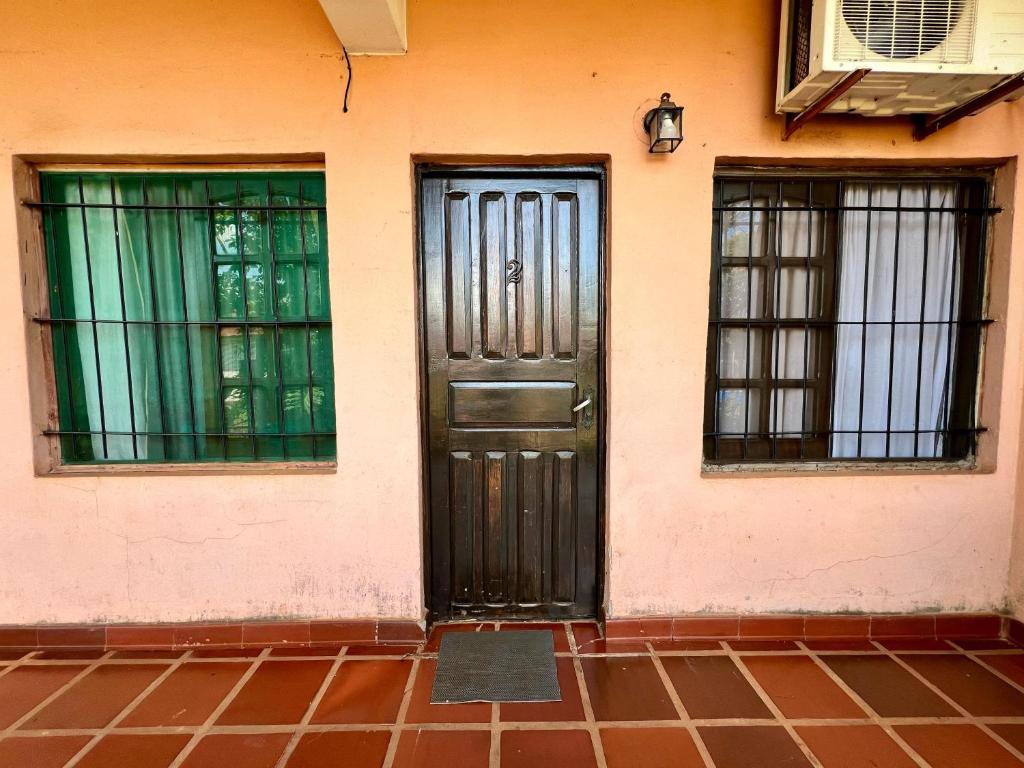 uma porta de uma casa com duas janelas em Selva Guazú Apart em Puerto Iguazú