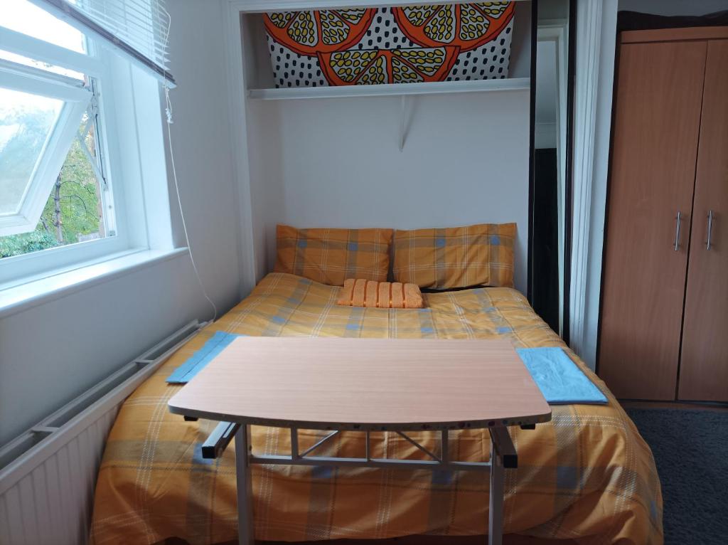 een klein bed in een kleine kamer met een tafel bij UnknownRooms in Londen