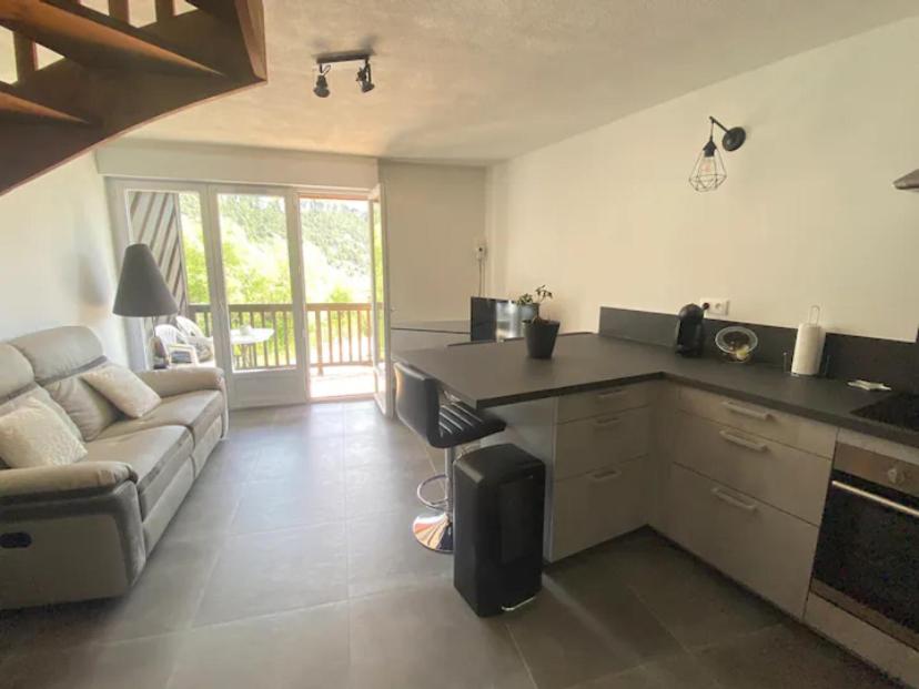 a kitchen and living room with a couch and a table at appartement T3 idéalement situé in Eygliers