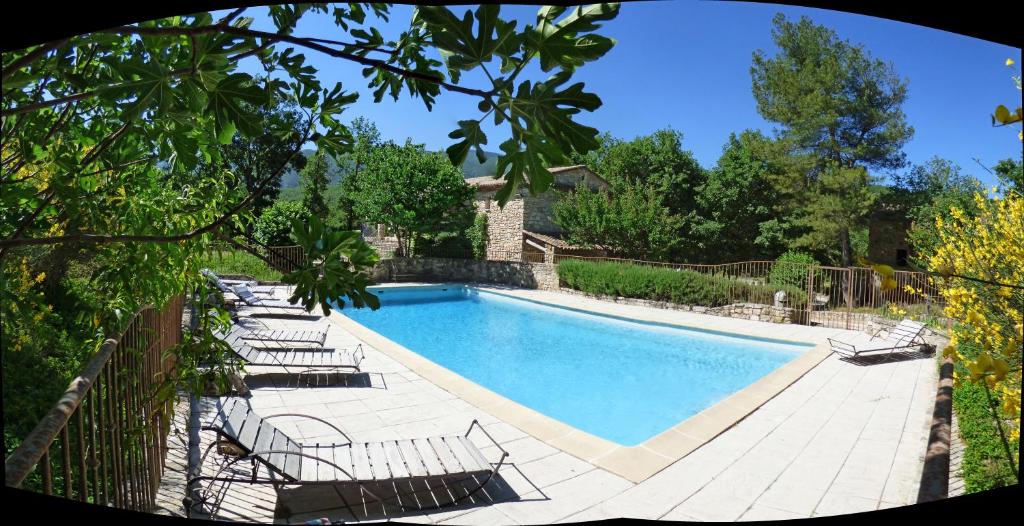 uma piscina com espreguiçadeiras ao lado de uma cerca em Hôtel Lou Caleù restaurant le Rocher des Abeilles em Saint-Martin-de-Castillon