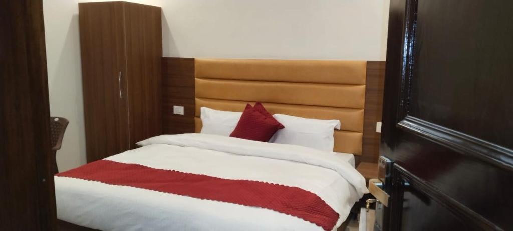 a bedroom with a bed with a red and white blanket at Butola Hotels in Rishīkesh