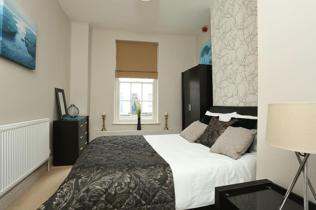 Un dormitorio con una cama grande y una ventana en Apartment in the heart of Cheltenham/ Parking, en Cheltenham