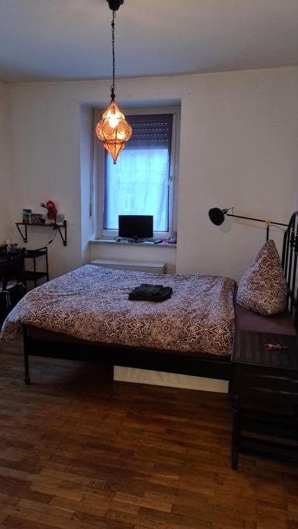 a bedroom with a bed and a window and a lamp at Gemütliches Zimmer in einer Altbauwohnung in der Stadt in Würzburg