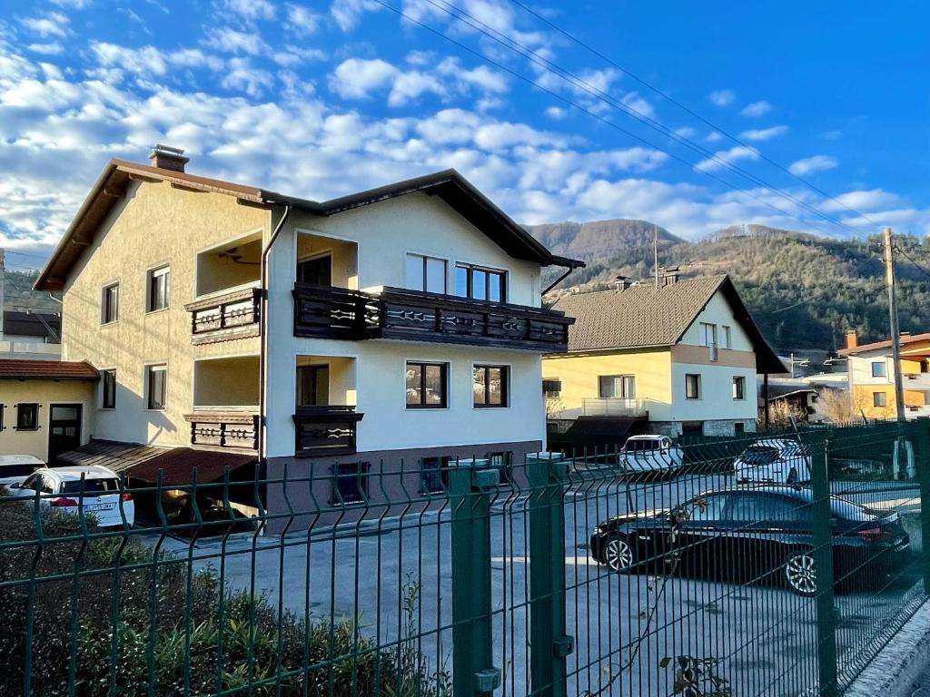 a white house with a fence in front of it at All Seasons Apartments Laško in Laško