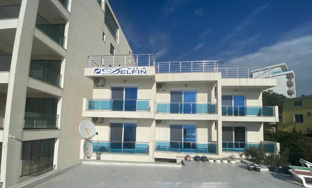 a large white building with a sign on it at Apartments Delfin in Bar