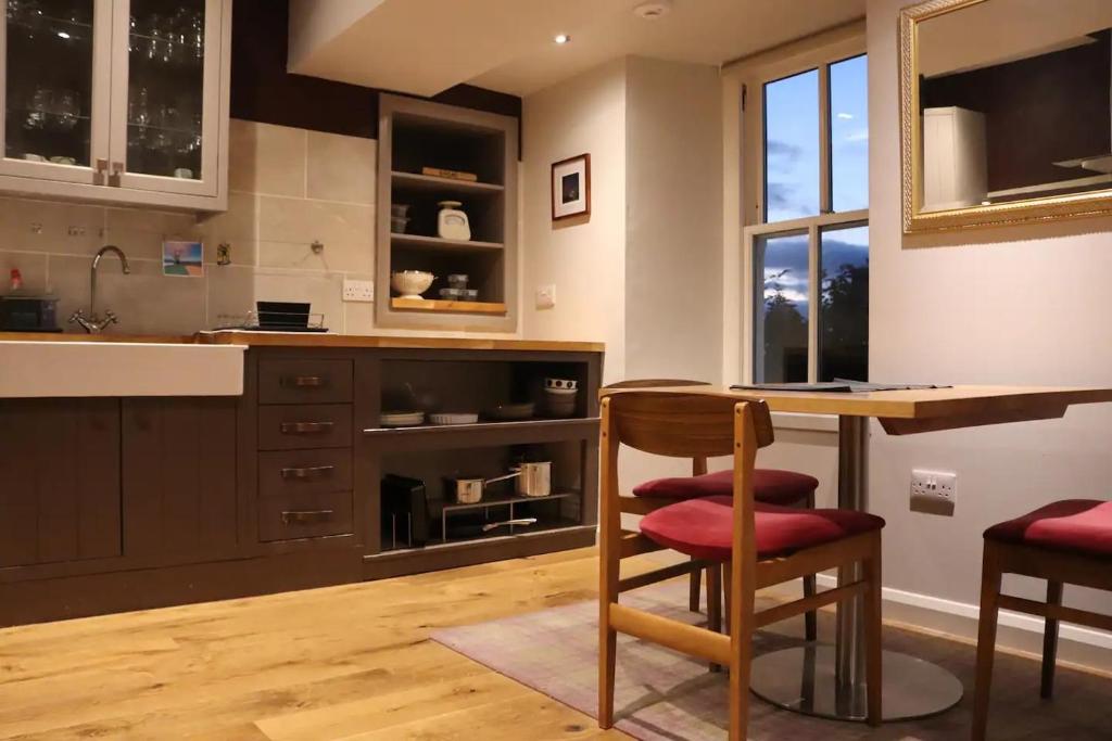 a kitchen with a table and chairs and a window at Unique Highland in Inverness