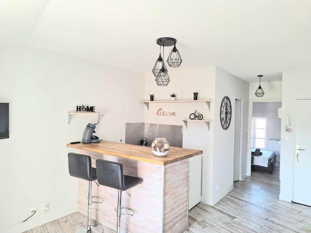 a kitchen with a counter with two stools at it at Appartement F2 centre-ville ISSOIRE avec jolie vue in Issoire