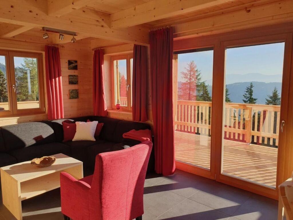ein Wohnzimmer mit einem Sofa und einem Balkon in der Unterkunft Klippitzstern House 2 in Klippitztorl