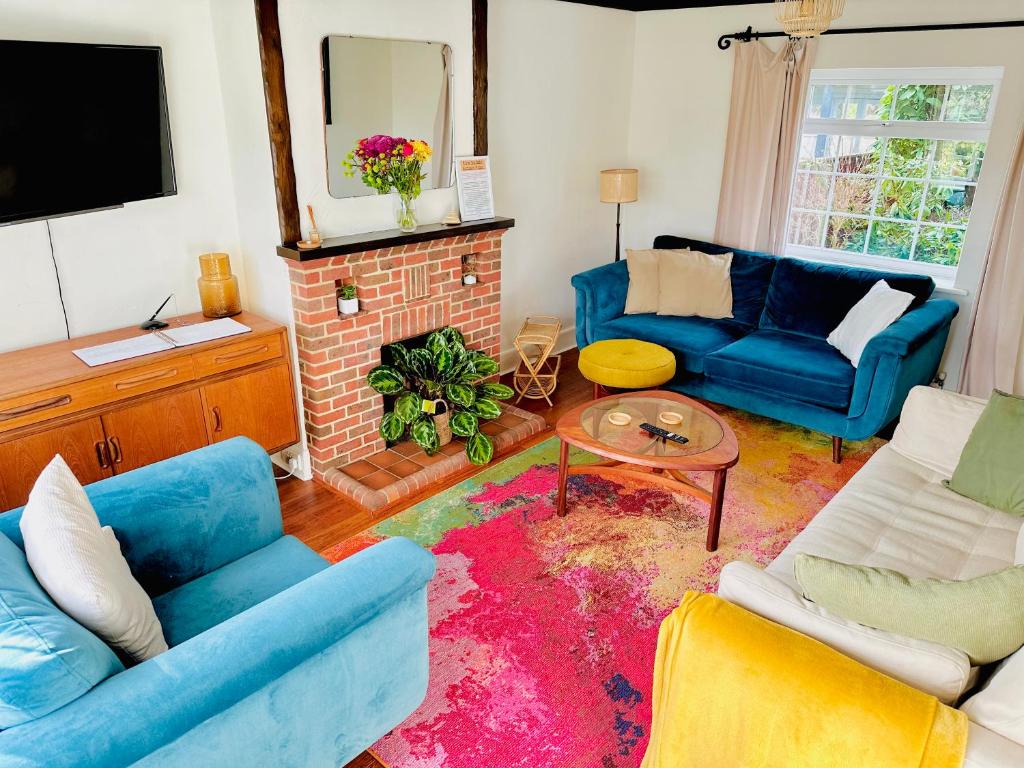 uma sala de estar com dois sofás azuis e uma lareira em Cooden Cottage em Bexhill