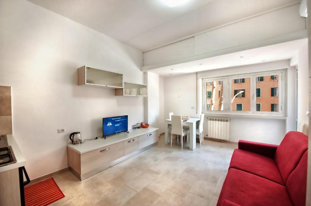 un salon avec un canapé rouge et une télévision dans l'établissement Appartamento Romantico a Trastevere, à Rome
