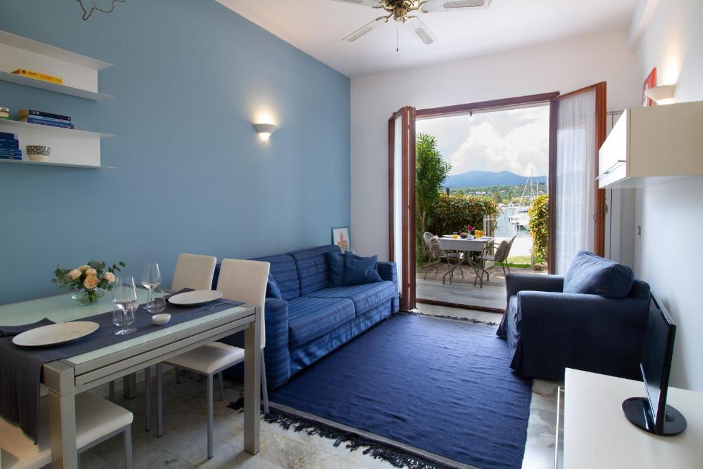 Una sala de estar con un sofá azul y una mesa. en Lakefront Belvedere by Garda FeWo, en Manerba del Garda