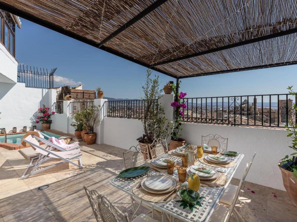 a table and chairs on a patio with a view of the ocean at Carmen de Azahar in Granada