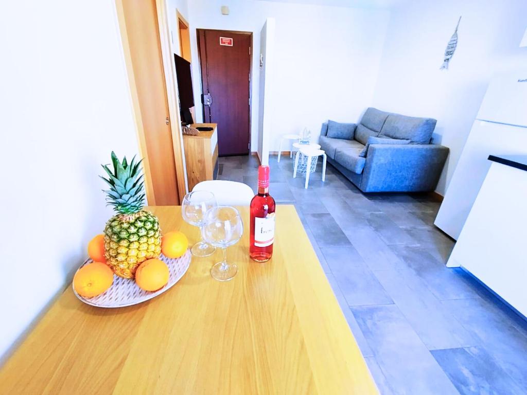 uma garrafa de vinho e um prato de fruta numa mesa em Appartement Clube Praia Da Rocha III em Portimão