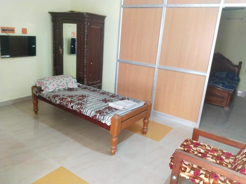 een kamer met een houten bank in een kamer bij Kamachi Residency in Chidambaram