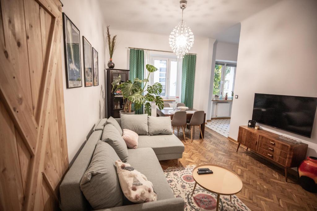 Apartament Miedziana City Center في وارسو: غرفة معيشة مع أريكة وتلفزيون