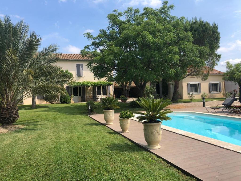 a house with a swimming pool and a yard at Petite Maison en Provence in Arles
