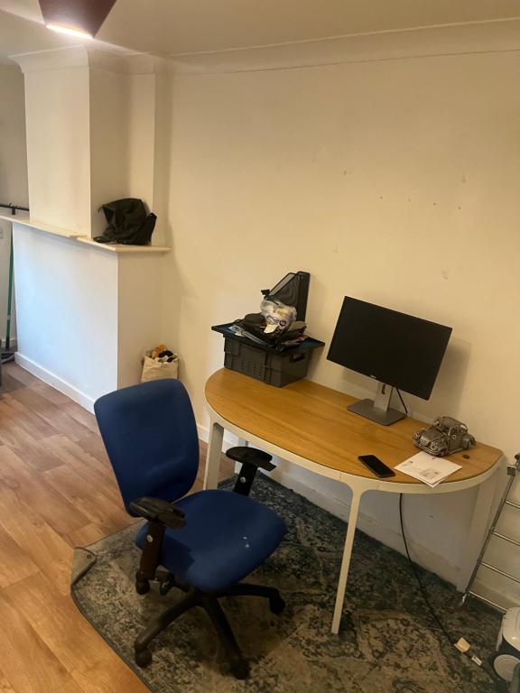 - un bureau avec un ordinateur et une chaise bleue dans l'établissement Sweet dream, à Londres