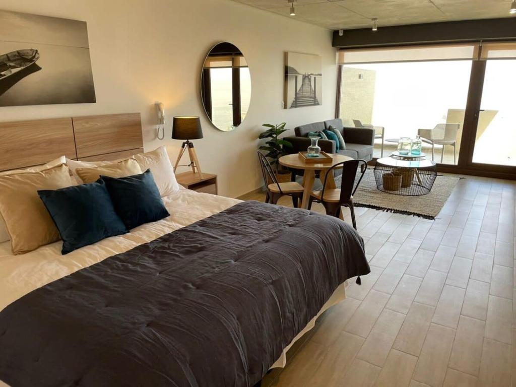 um quarto com uma cama grande e uma sala de estar em HOM I TOP1 NUEVO STUDIO en mejor zona Valparaíso Parking em Valparaíso