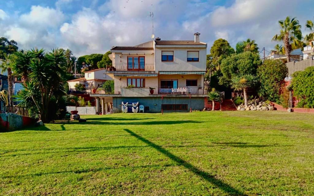een huis met een grote tuin ervoor bij Villa Azumí in Santa Susanna
