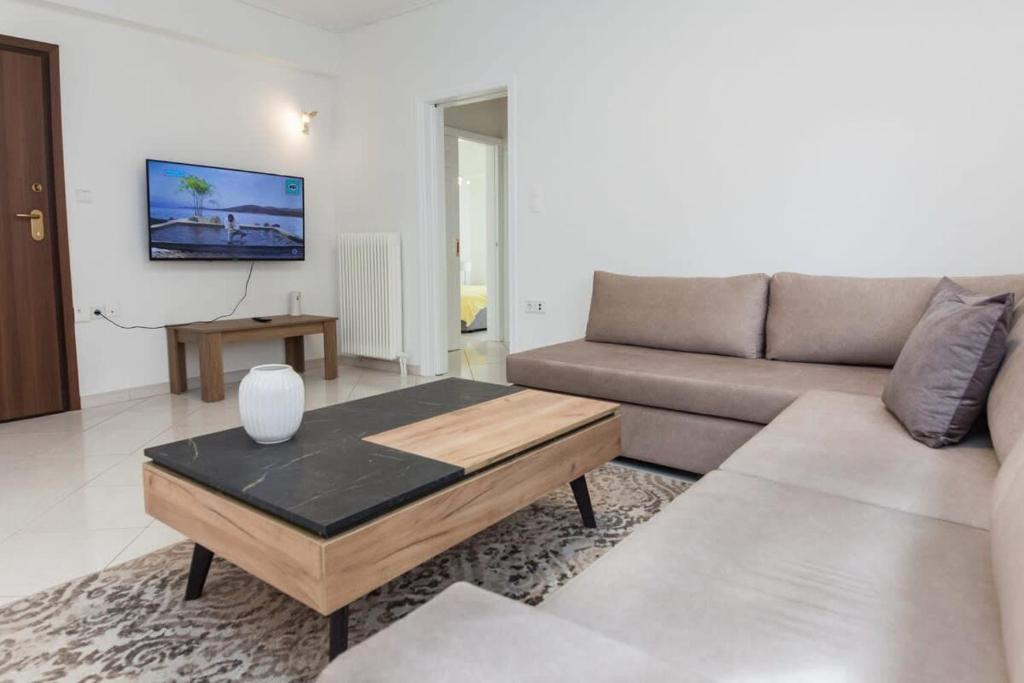 ein Wohnzimmer mit einem Sofa und einem Couchtisch in der Unterkunft Faliro 2 Bd Escape Modern Living Redefined in Athen