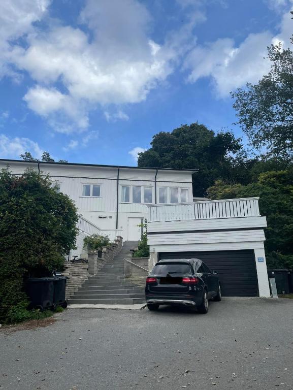 a car parked in front of a building with a garage at Fin uthyrningsdel med egen terass in Kungsängen