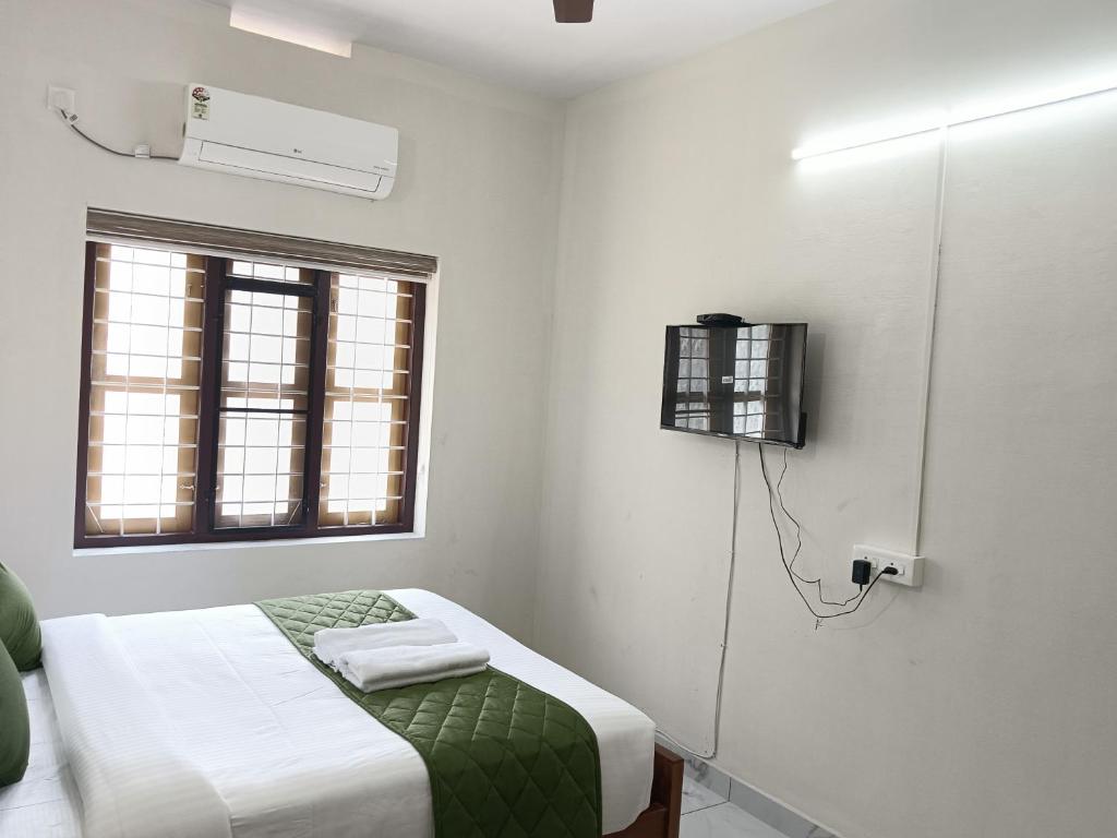 Postel nebo postele na pokoji v ubytování Greenview Royal Stay Near Amrita Hospital Edappally