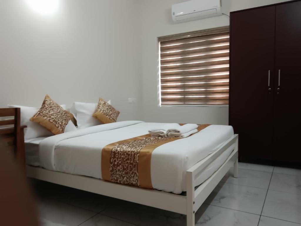 Postel nebo postele na pokoji v ubytování Greenview Royal Stay Near Amrita Hospital Edappally