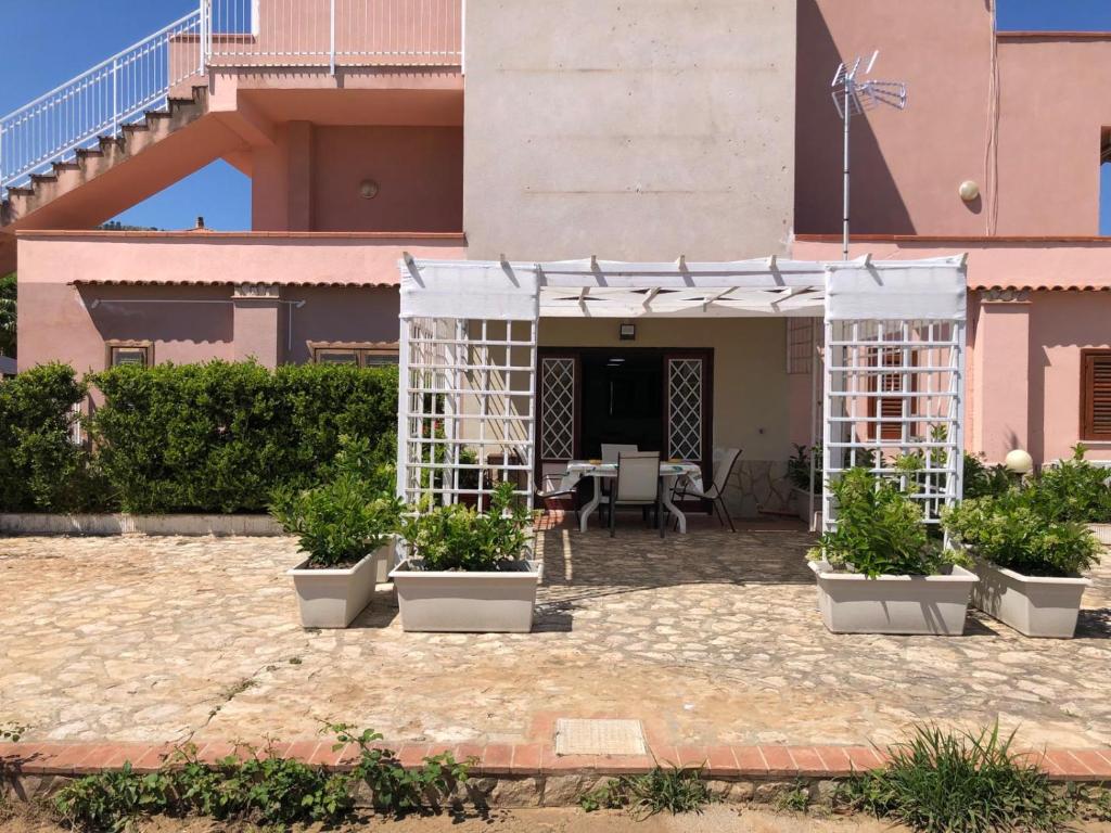 a patio with potted plants in front of a building at Milicia Apartment in Mandra Capreria