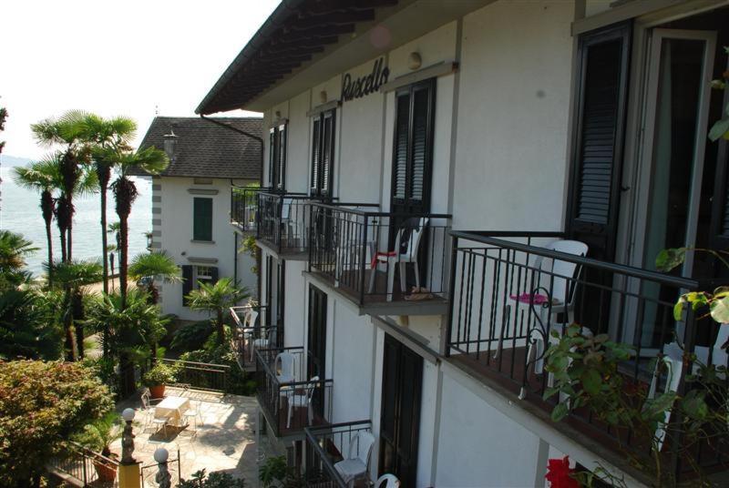 an apartment building with balconies and tables and chairs at Hotel Villa Ruscello in Baveno