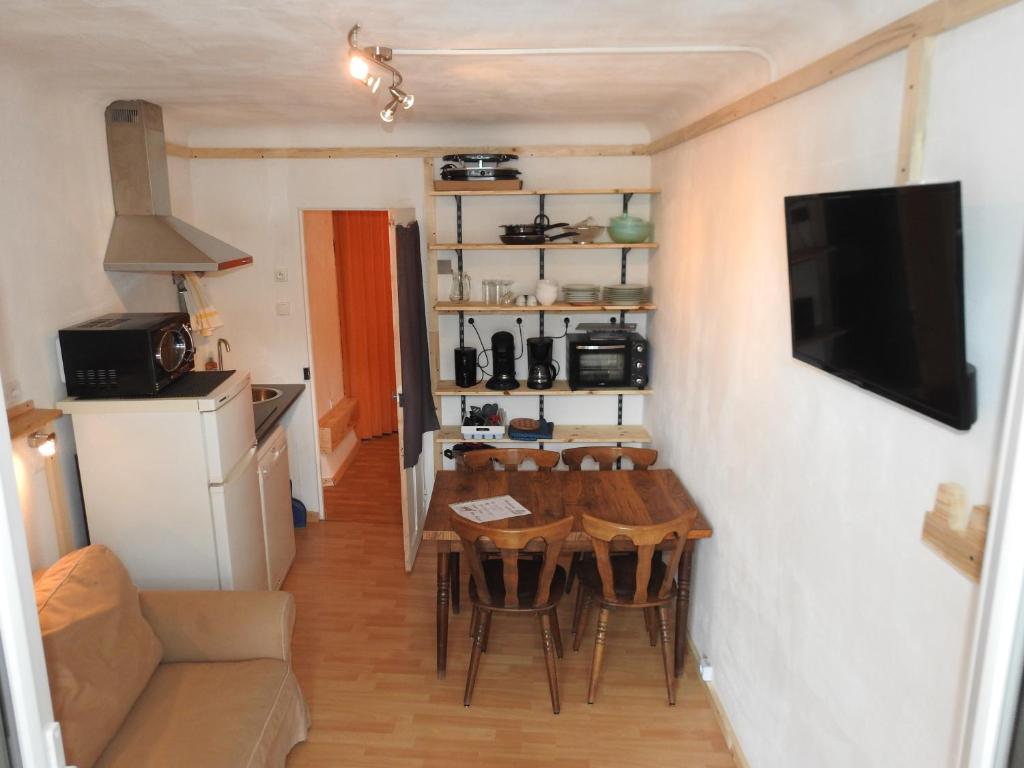 a small kitchen and dining room with a table and chairs at A découvrir joli petit Appart au coeur du village in Vallouise