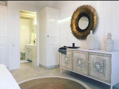 uma casa de banho com uma cómoda com um espelho na parede em Luxury Sunset em Míconos