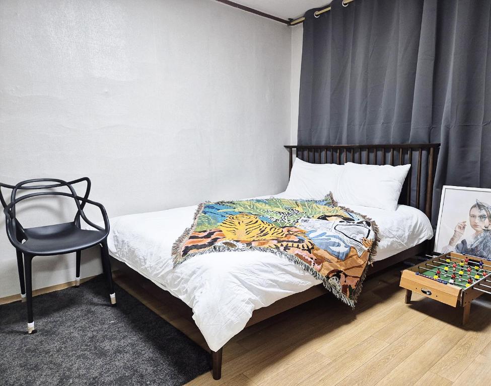 a bedroom with a bed and a chair and a table at Stay in North Seoul in Seoul