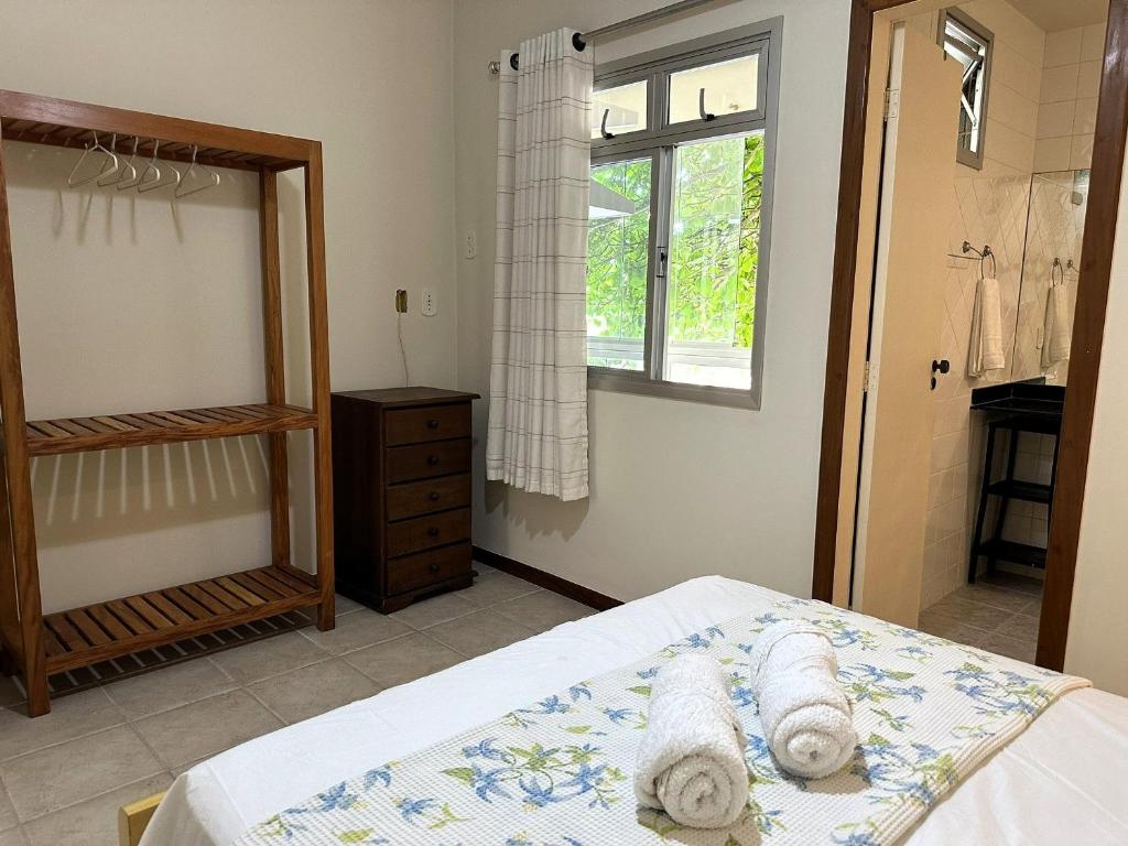a bedroom with a bed with towels on it at Aconchegante 2Q em frente a praia Ponta da Fruta in Ponta da Fruta