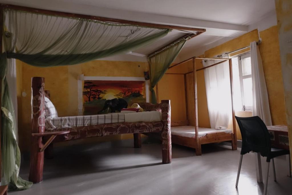 a bedroom with a canopy bed with a mirror at Diani Peaceful Garden in Diani Beach