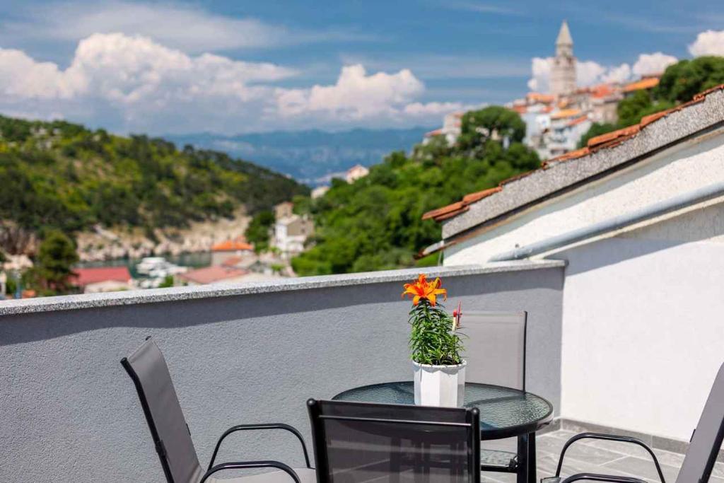 a table with a flower on top of a balcony at Apartment in Vrbnik - Insel Krk 45252 in Vrbnik
