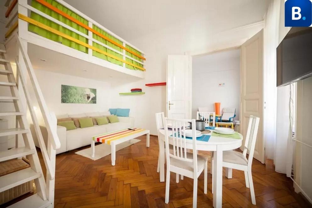 a living room with a table and a loft bed at Jókai Apartment in Budapest